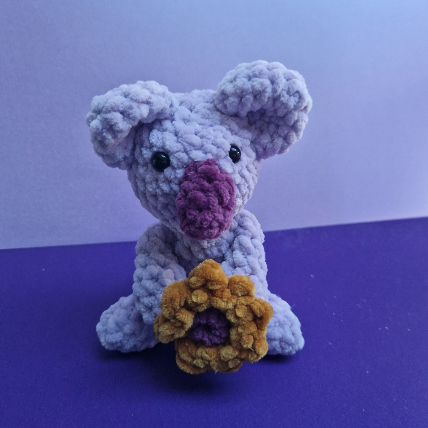 Crochet chunky, super soft lilac and purple koala holding a sunflower