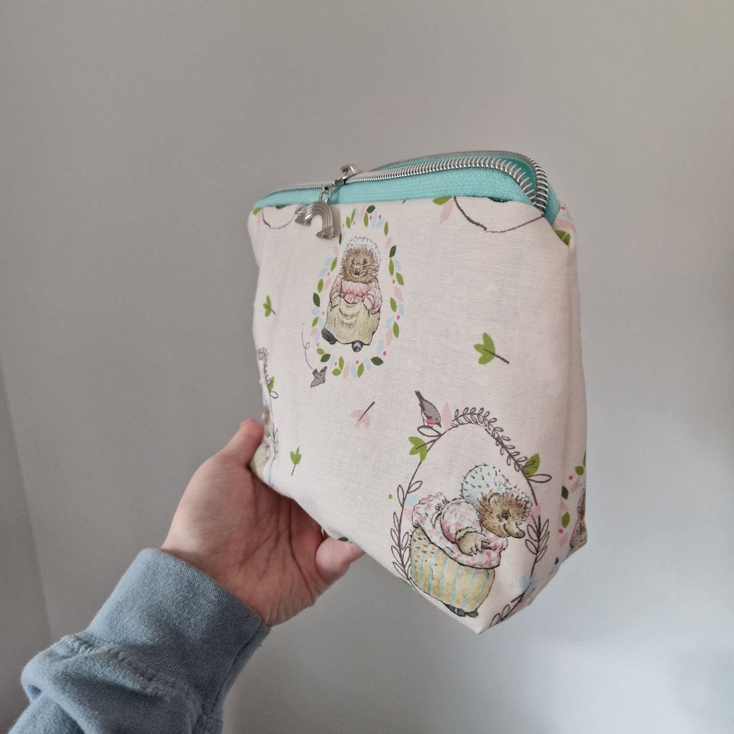 Hedgehog themed lined triangle cosmetic bag with matching zipper pull